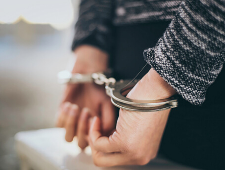 Close-up of youth's hands handcuffed behind his back